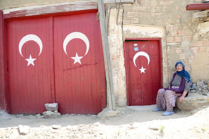 Köye gelenleri Türk bayrakları karşılıyor
