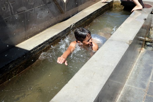 Aydıncık’ta sıcaktan bunalan çocuklar, mahalle çeşmesinin oluğunda yüzüp çeşme kenarında